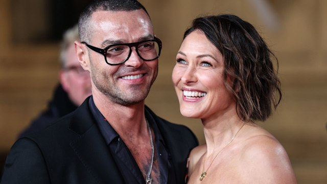 Matt Willis in a black shirt with his wife Emma Willis in a strapless dress