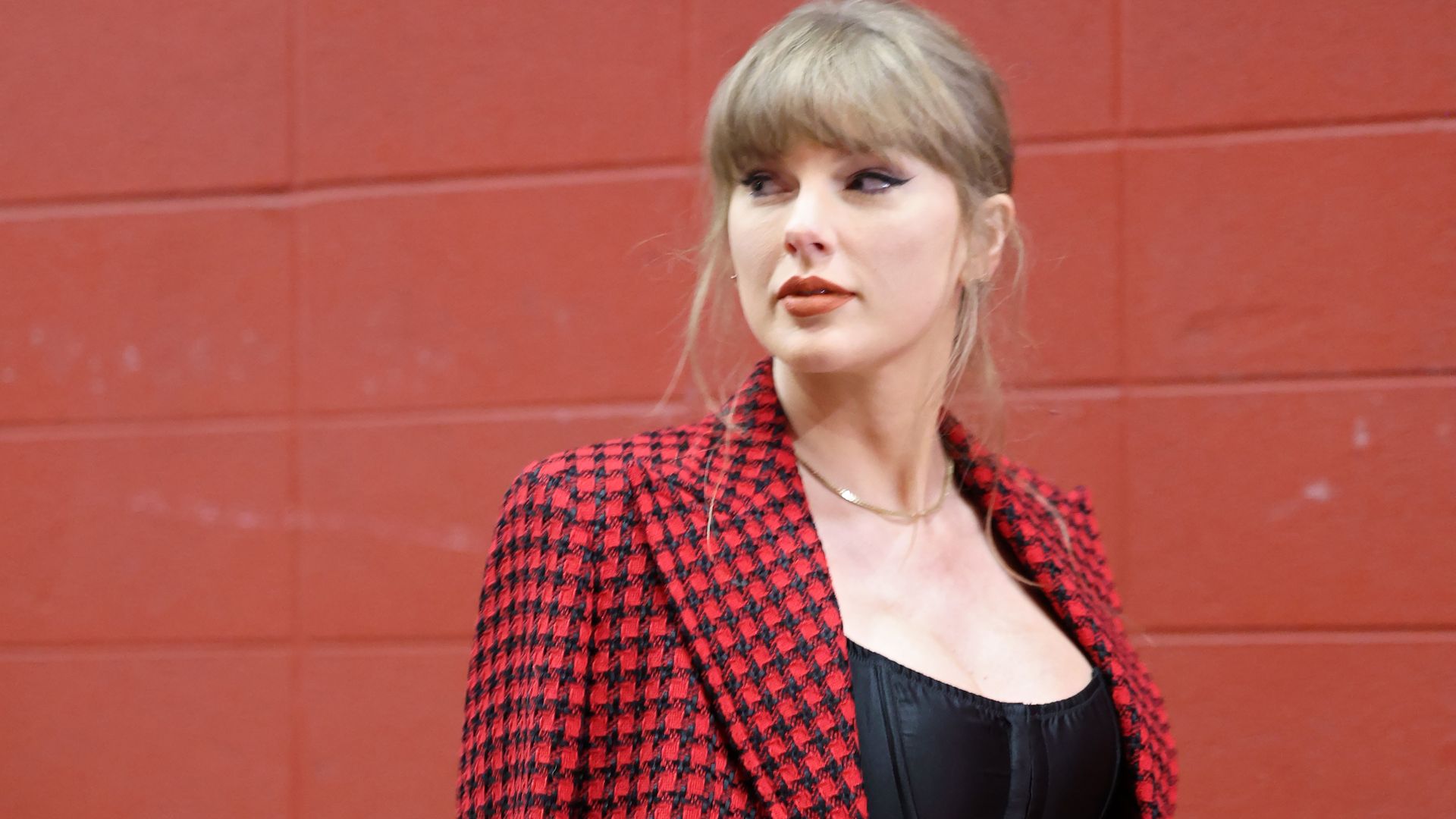 Taylor Swift shows she means business in $5K red Versace suit as she supports Travis Kelce