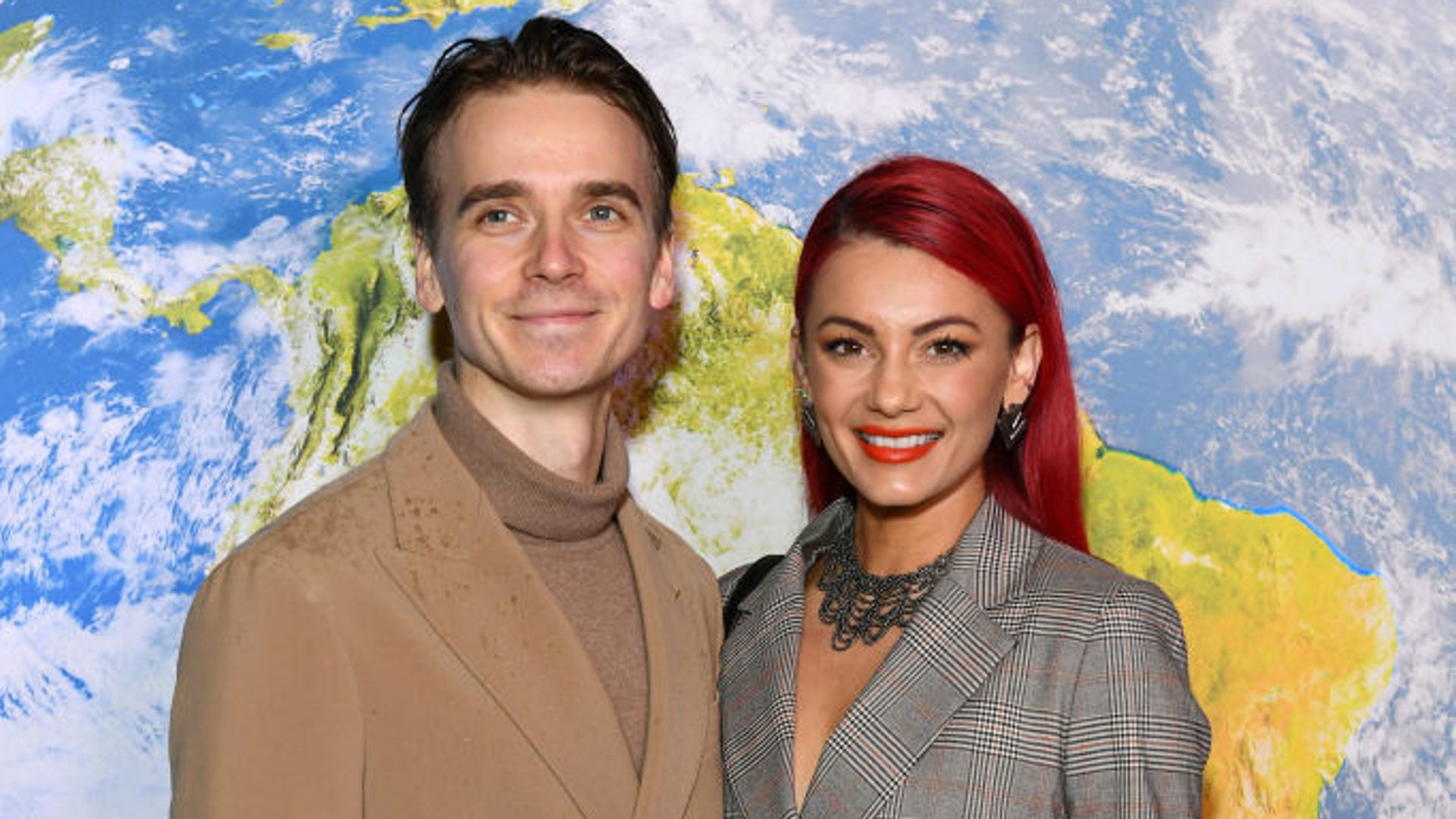 oe Sugg and Dianne Buswell attend the "BBC Earth Experience" launch at the Daikin Centre on March 29, 2023. He is wearing a camel coat and she is dressed in a grey check blazer. 