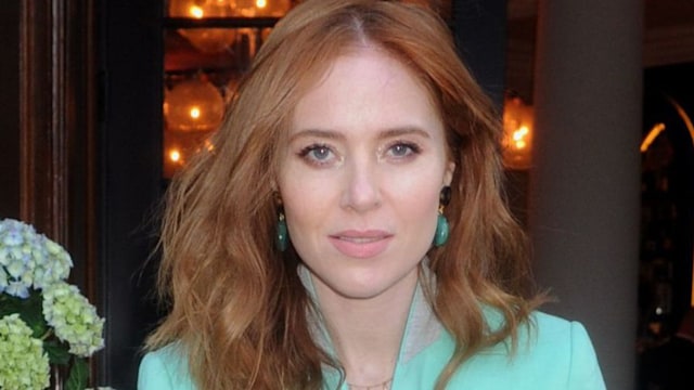 Angela Scanlon in a green suit near flowers 