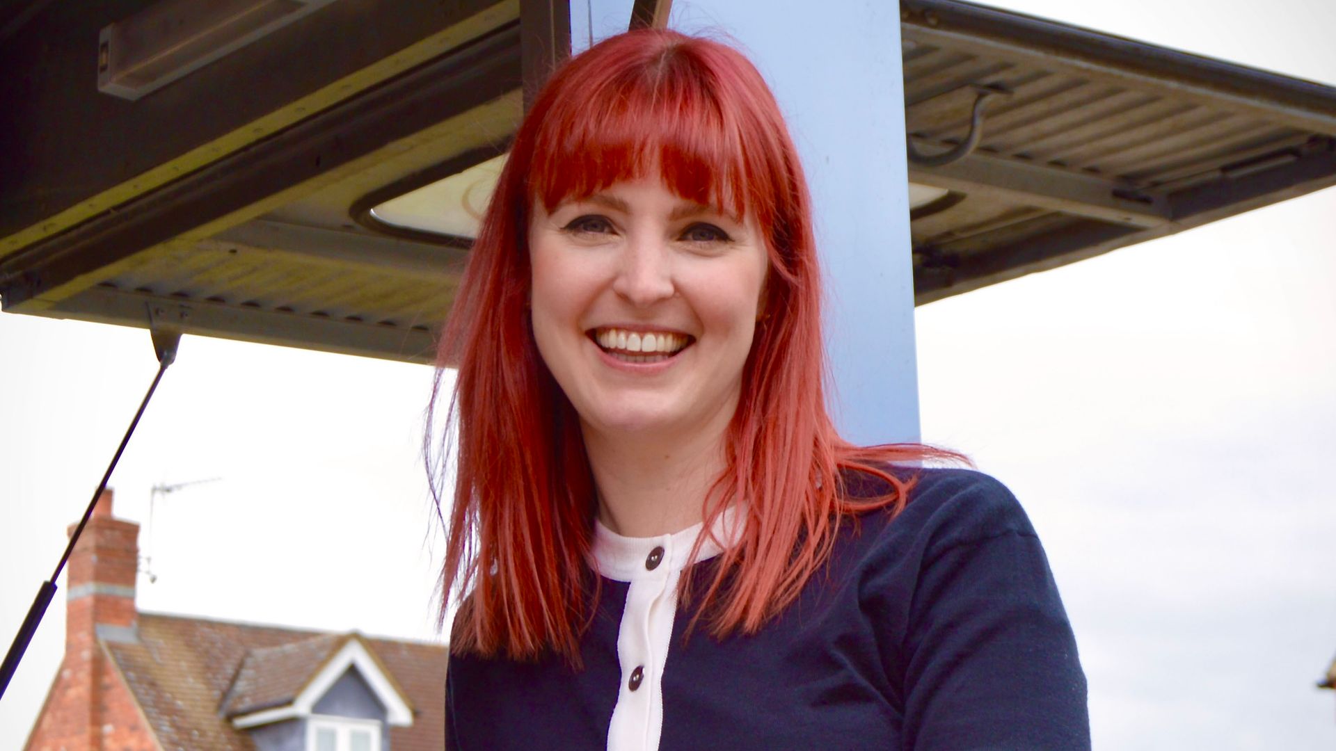 Woman with red hair standing in front of the restoration van
