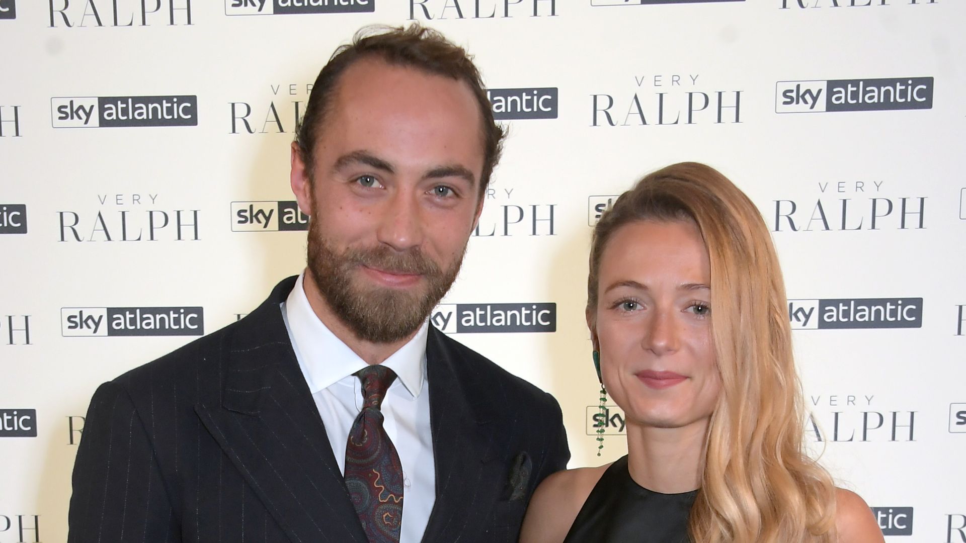 James Middleton standing with wife Alizee, both in black