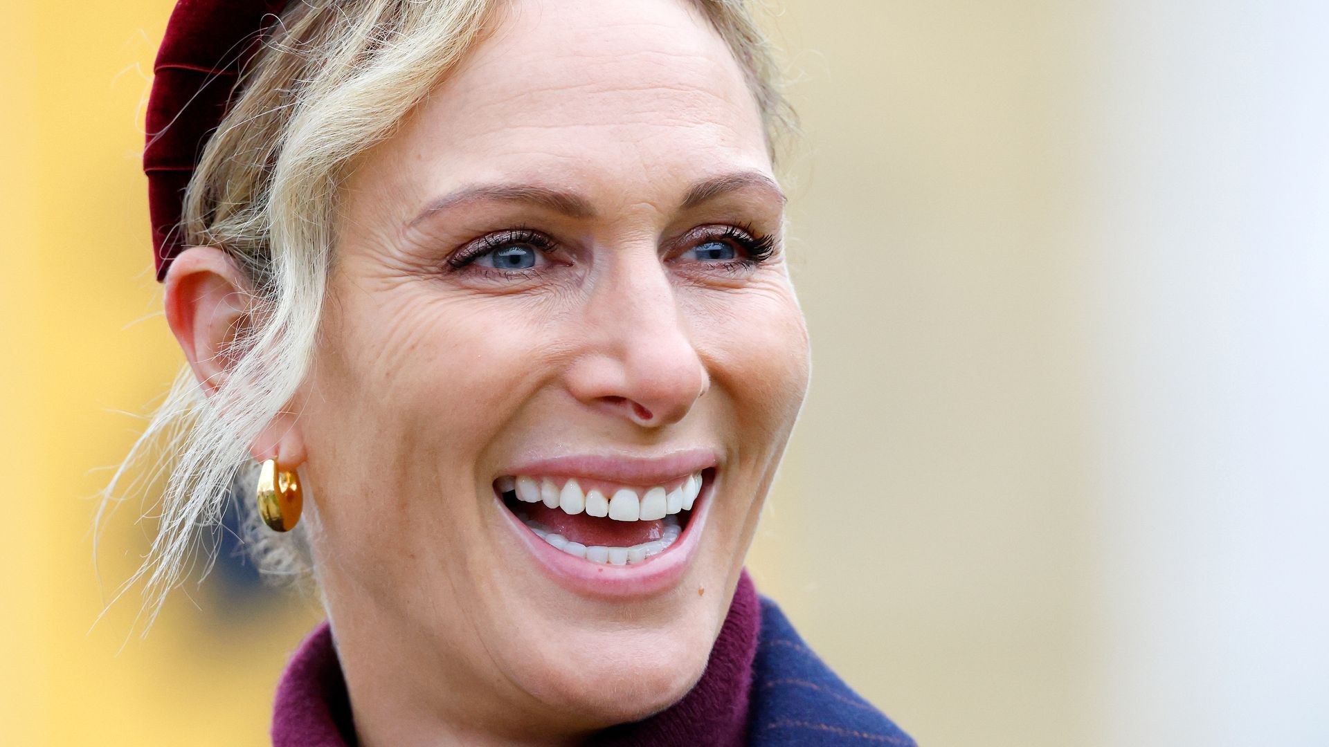 woman smiling in pinstripe suit and headband