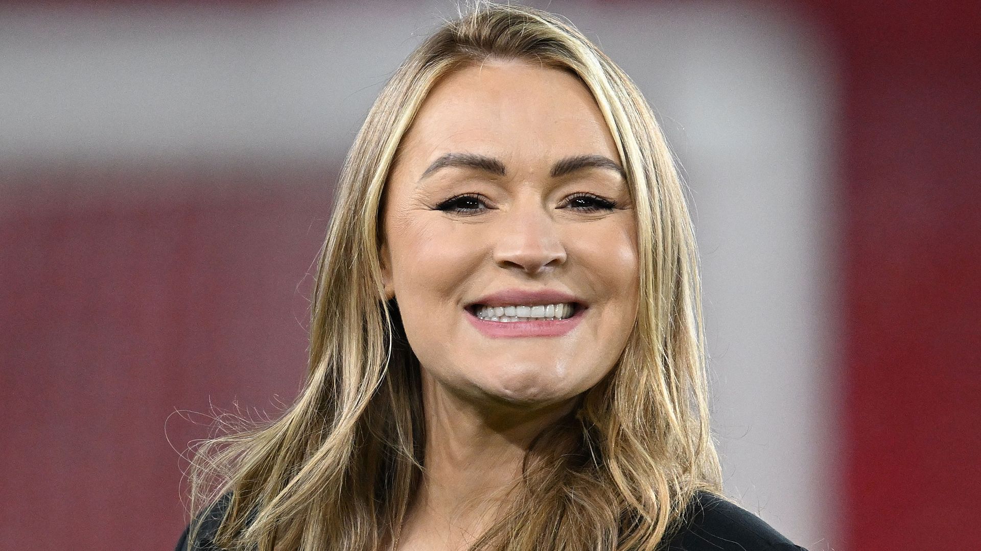 Laura Woods smiling in a black outfit