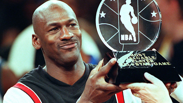 NEW YORK, UNITED STATES:  Chicago Bulls' Michael Jordan holds up the Most Valuable Player trophy which he earned in leading the Eastern Conference to victory in the NBA All-Star Game at Madison Square Garden 08 February. Jordan won his third MVP award by scoring 23 points as the Eastern Conference All-Stars beat the Western Conference 135-114.   AFP PHOTO  Tim CLARY (Photo credit should read TIM CLARY/AFP via Getty Images)