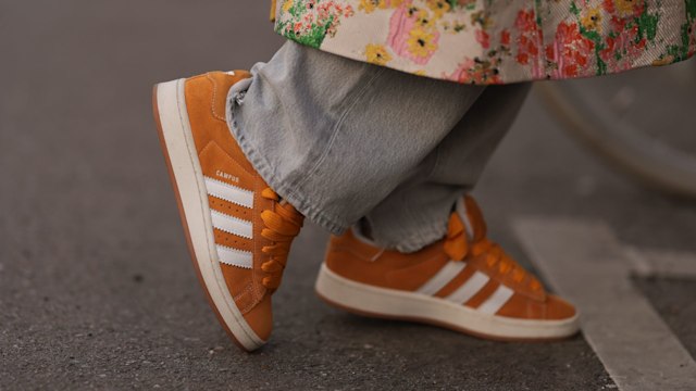 Karin Teigl seen wearing Agolde light grey denim straight leg pants, Stine Goya yellow with colorful flower embroidered pattern long coat and Adidas Campus orange suede leather sneakers, on March 23, 2024 in Munich, Germany. (Photo by Jeremy Moeller/Getty Images)