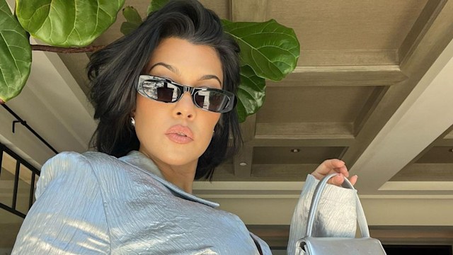Kourtney Kardashian wears a silver outfit and micro sunglasses