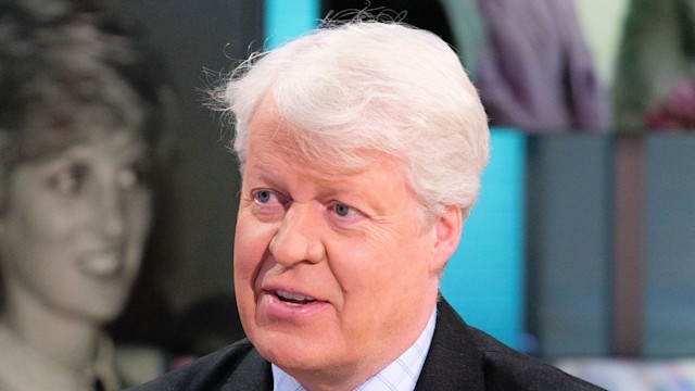 man talking in black suit and blue tie 