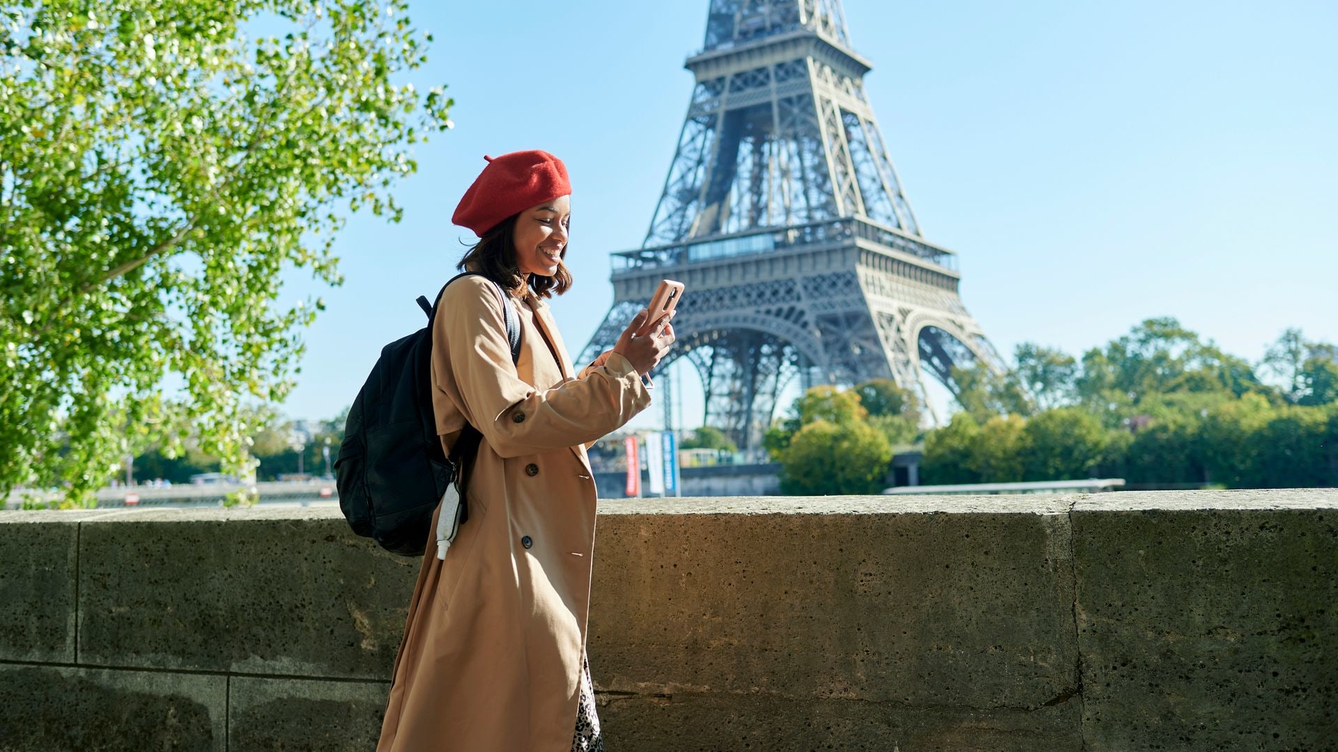 Woman walking using mobile phone with Eiffel Tower in the background