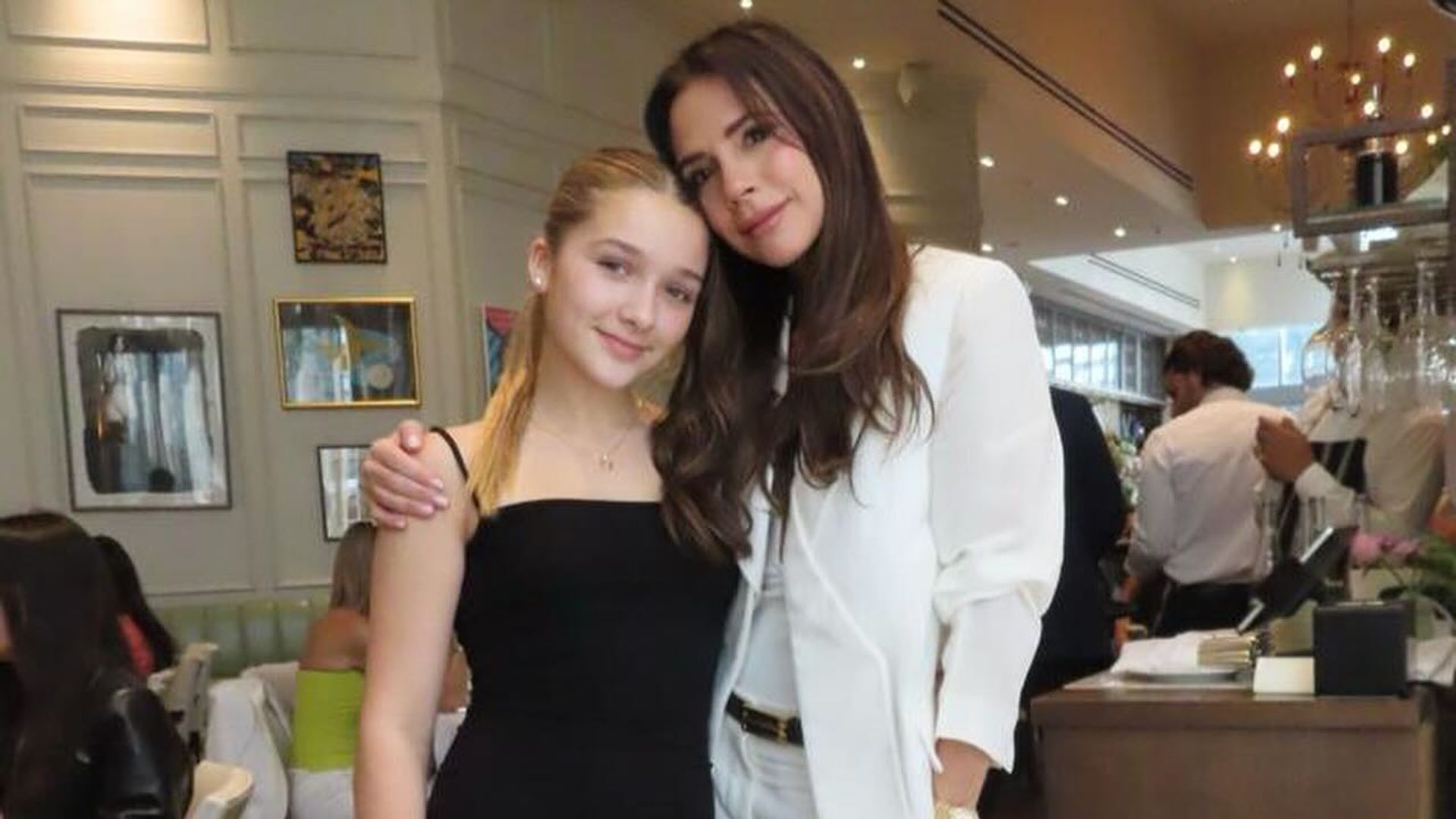 Victoria Beckham in white suit and harper in black dress