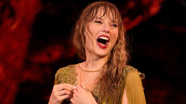 taylor swift smiling on stage in green