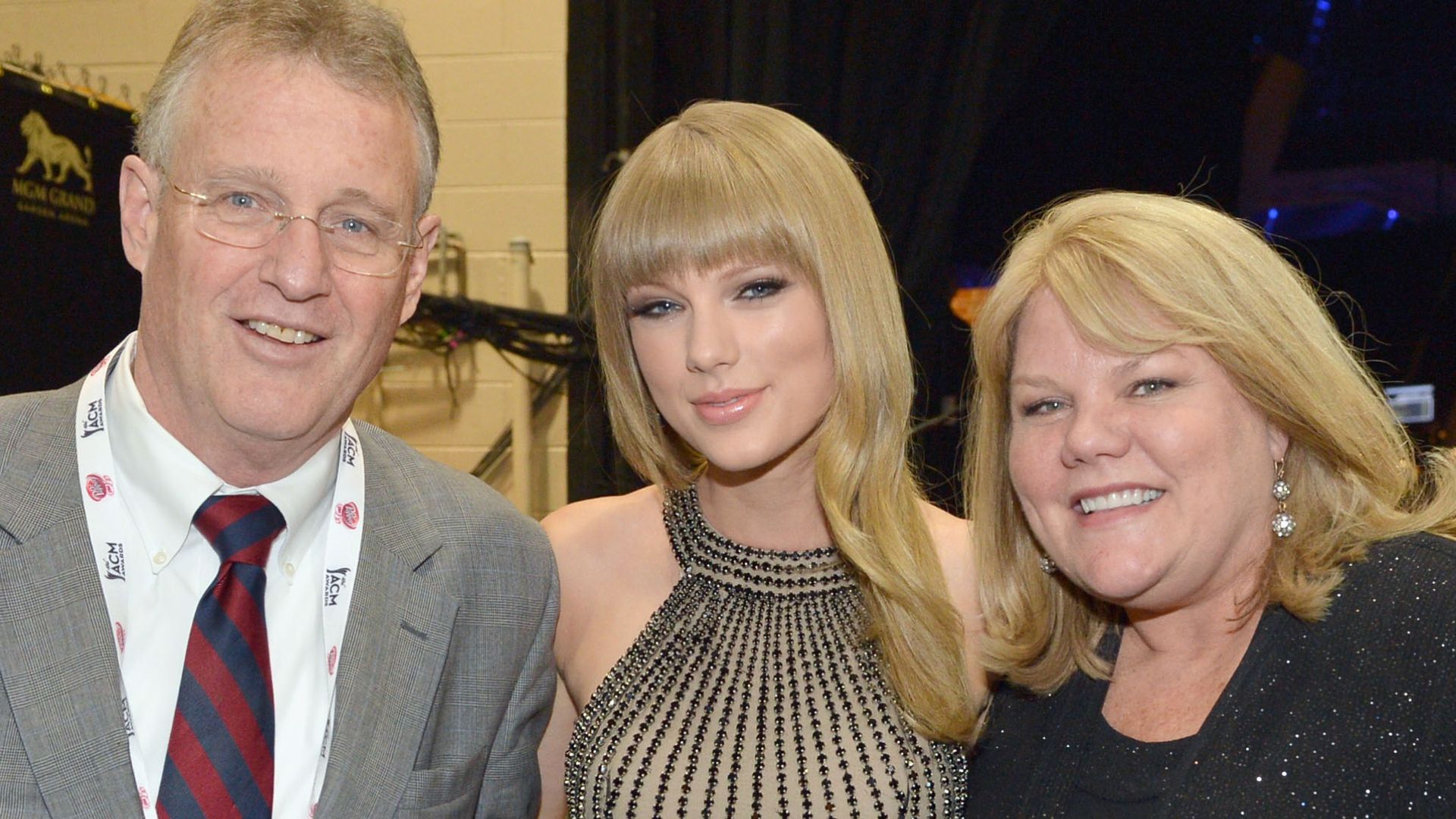 Taylor Swift smiling with her parents Scott and Andrea Swift