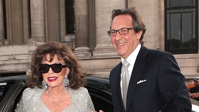 Joan Collins wearing a silver dress alongside her husband Percy Gibson