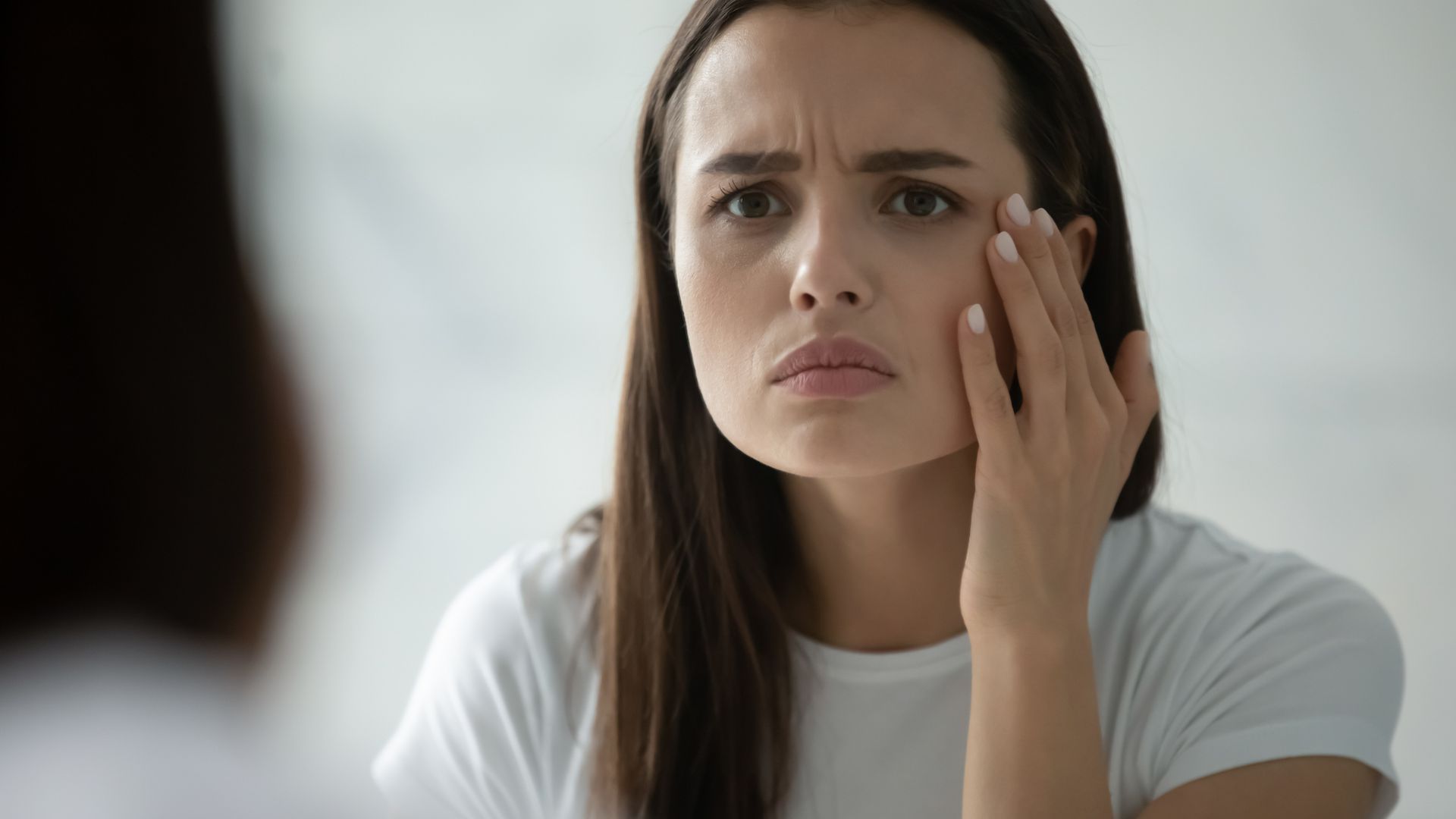 woman in mirror stressed out.