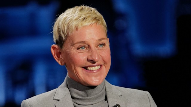 Ellen DeGeneres wears a grey suit and smiles as she stars on Jimmy Kimmel Live