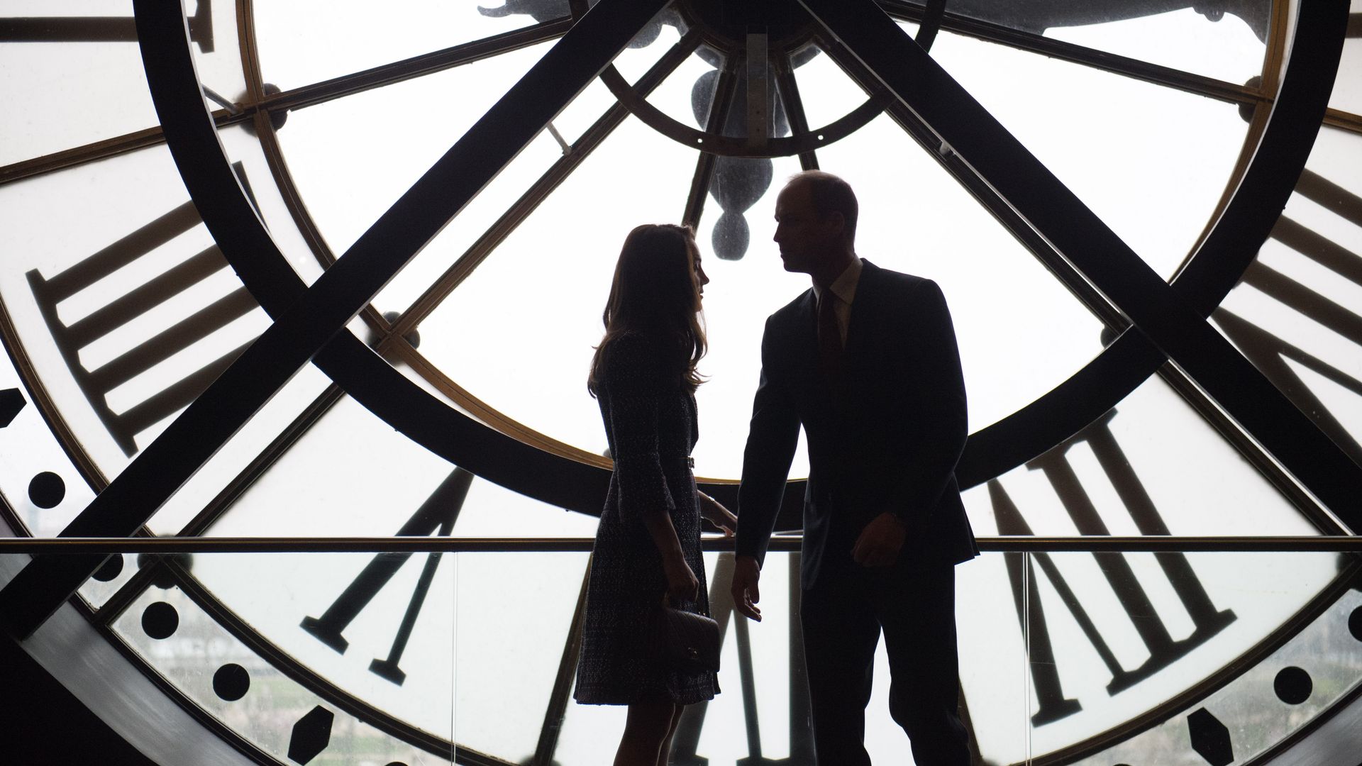 couple looking through large clock in museum