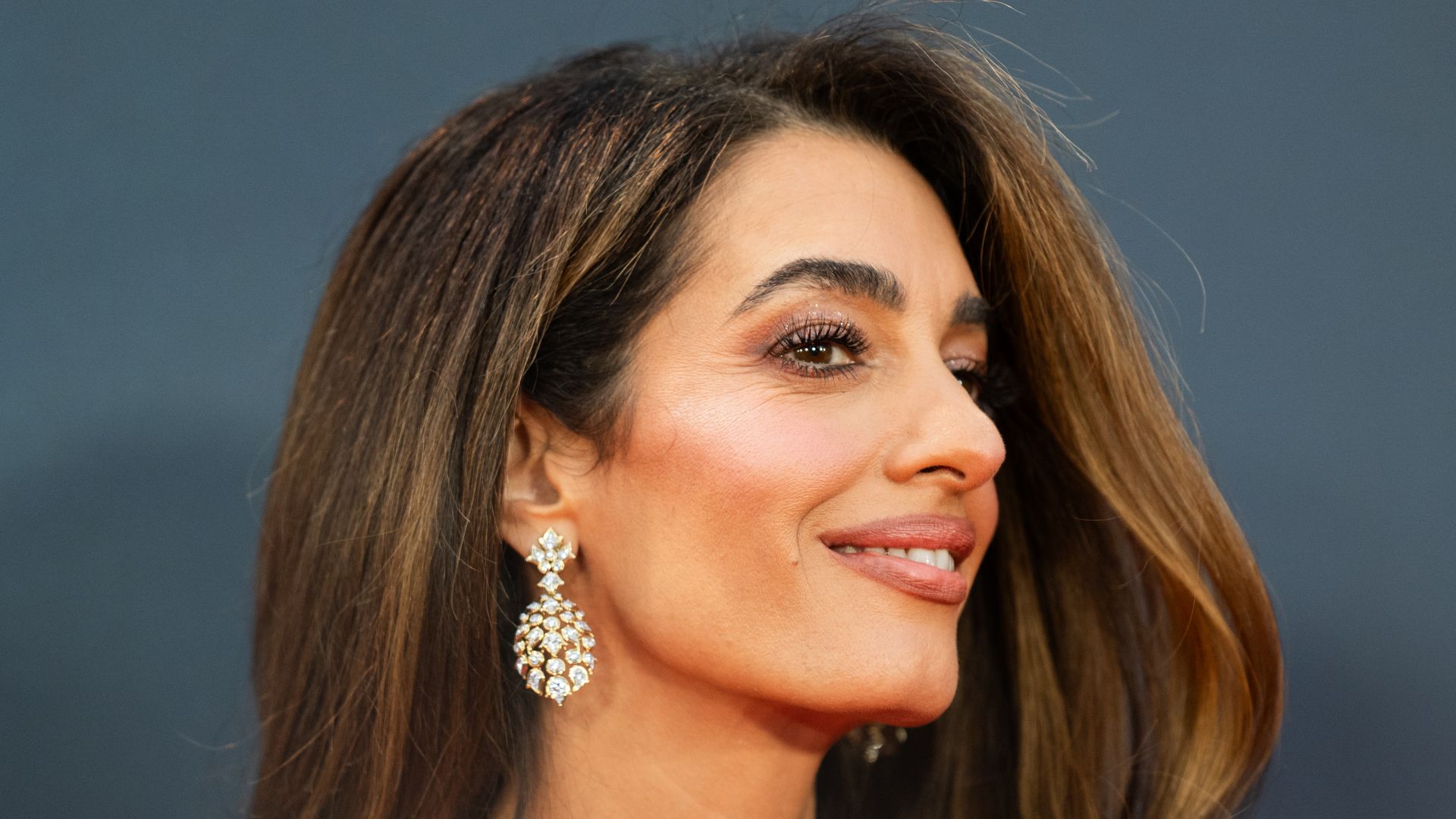 Amal Clooney looking to right in strapless pink dress
