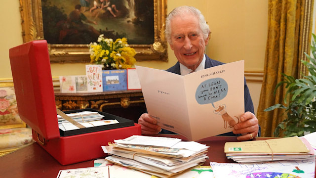 King Charles smiling and reading get well card