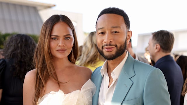 Chrissy in white silk with a floral crop top with john in blue suit