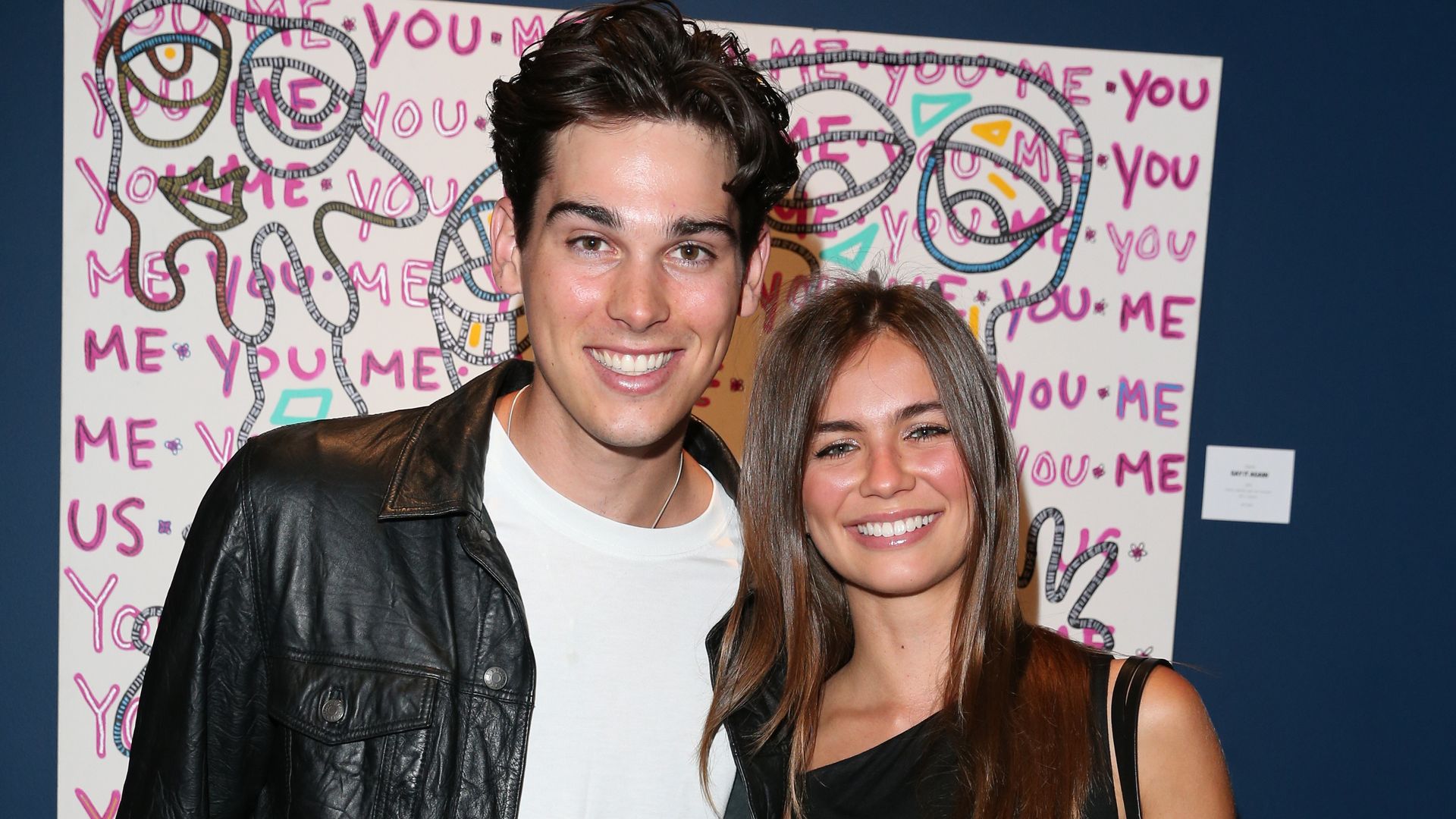 paris brosnan posing for photo with girlfriend alex lee aillon in front of his painting