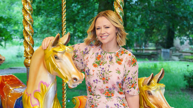 Kimberley Walsh wears pink floral dress as she poses with horse carousel ride