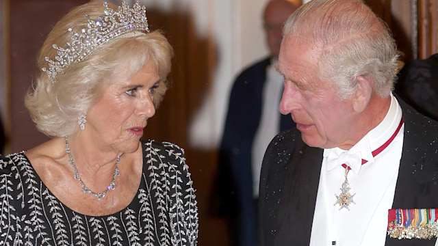 Queen Camilla in a tiara looking at King Charles