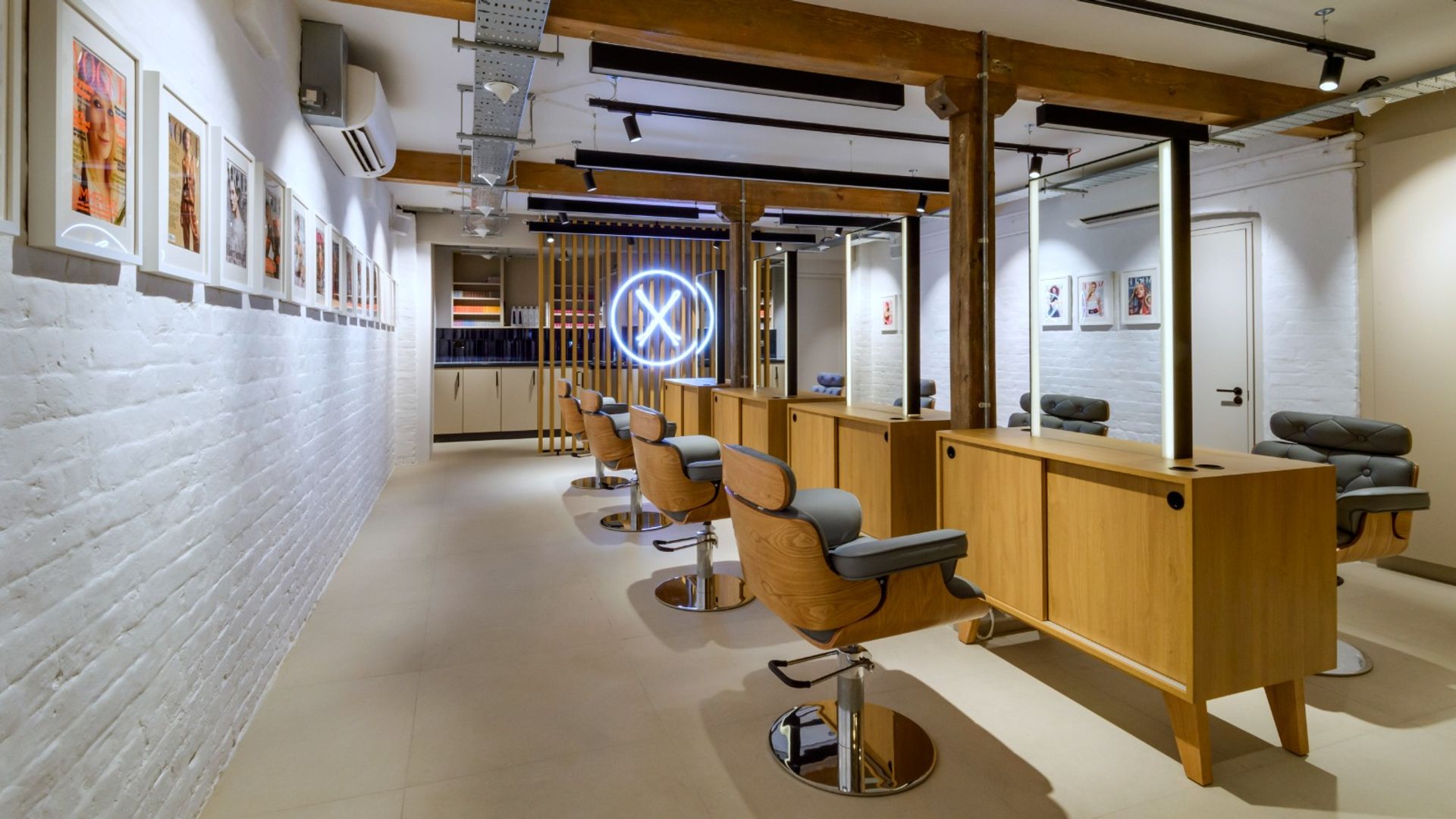 Wood-backed grey salon chairs with mirrors at Neil Moodie Studio