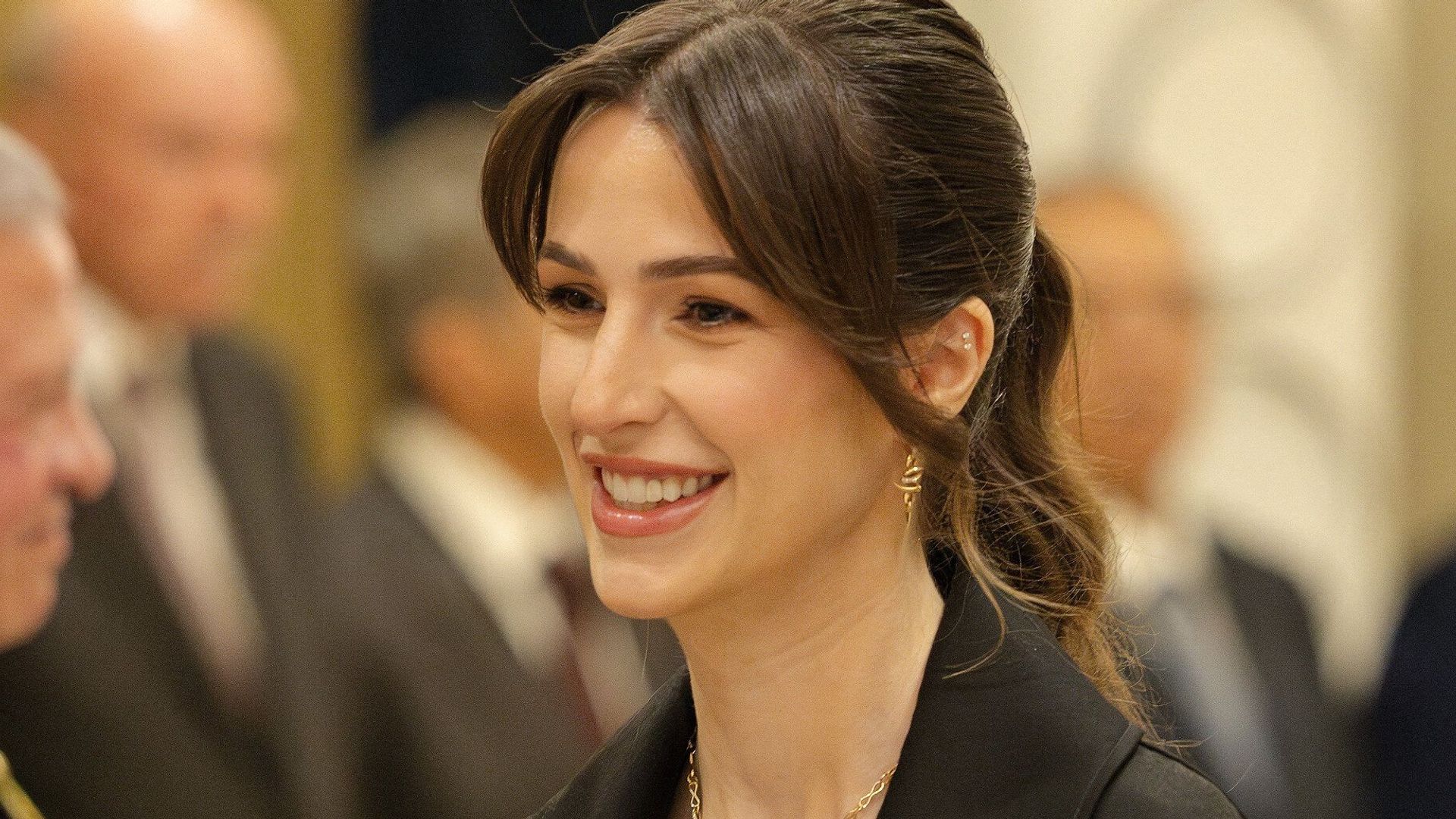 Princess Rajwa in a black belted jacket with her hair up