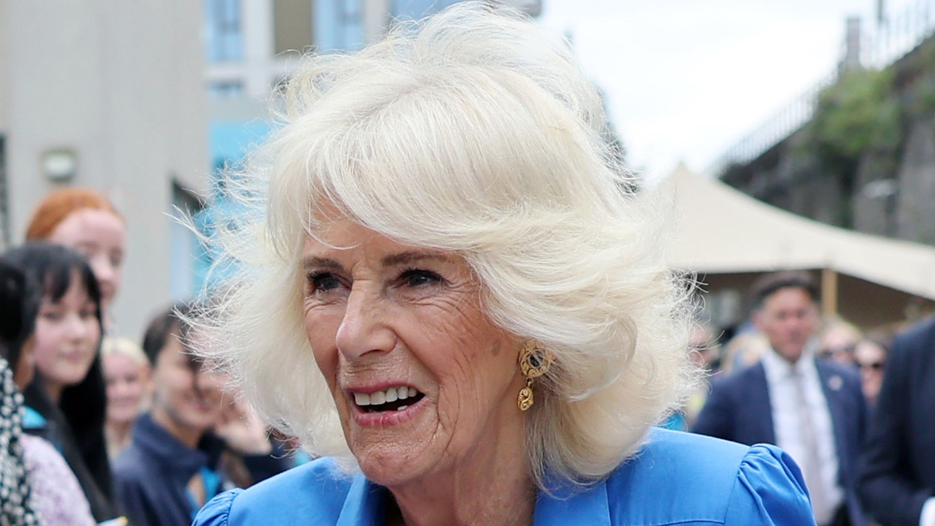 queen camilla smiling in blue dress