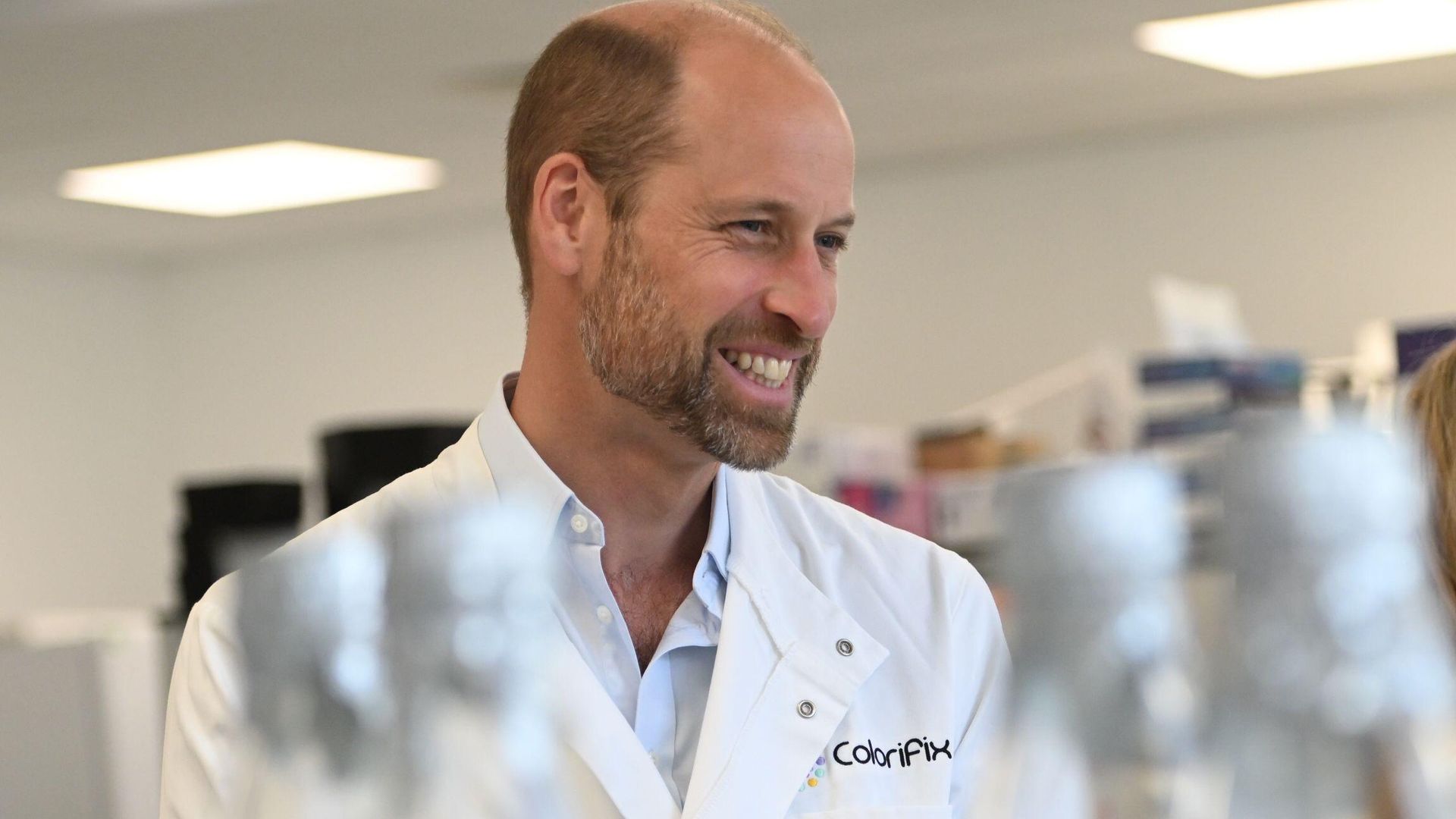 Prince William smiling in a lab coat