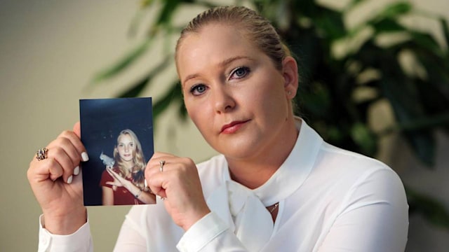 photo of virginia giuffre holding a photo of herself as a teenager