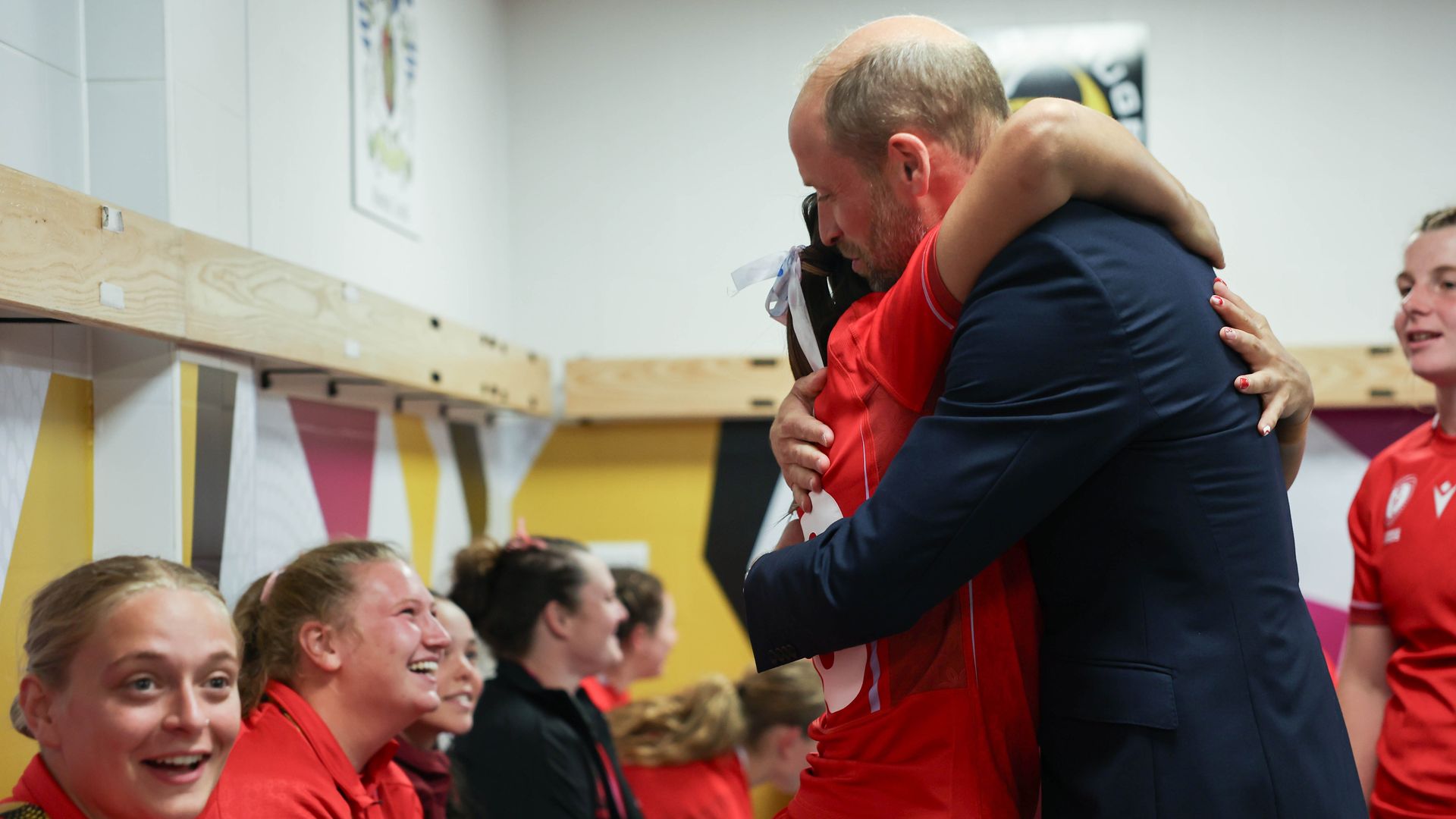 Prince William hugging a member of the Welsh women's rugby team
