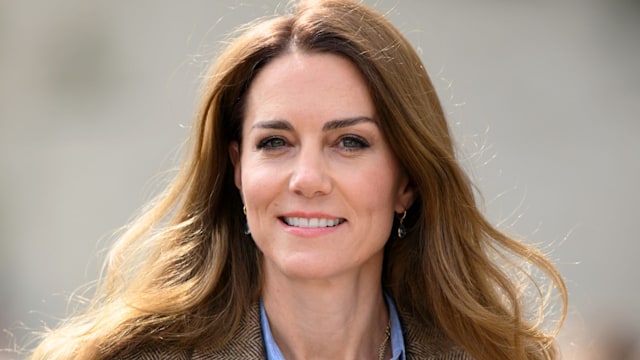 kate middleton smiling in checked jacket and blue shirt