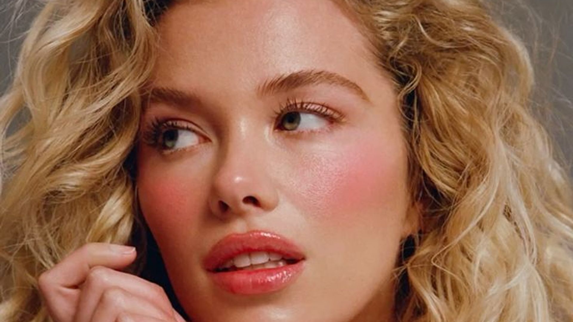 woman with curls and pink blush 