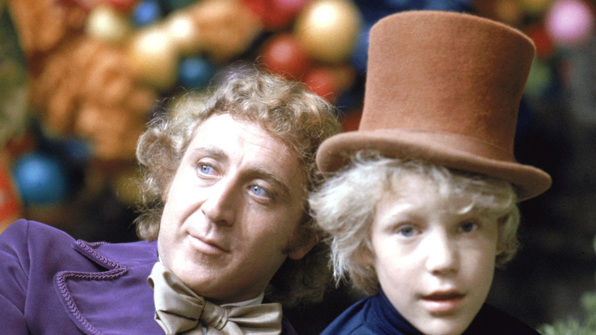 Gene Wilder as Willy Wonka sat with Peter Ostrum, who has character's hat on