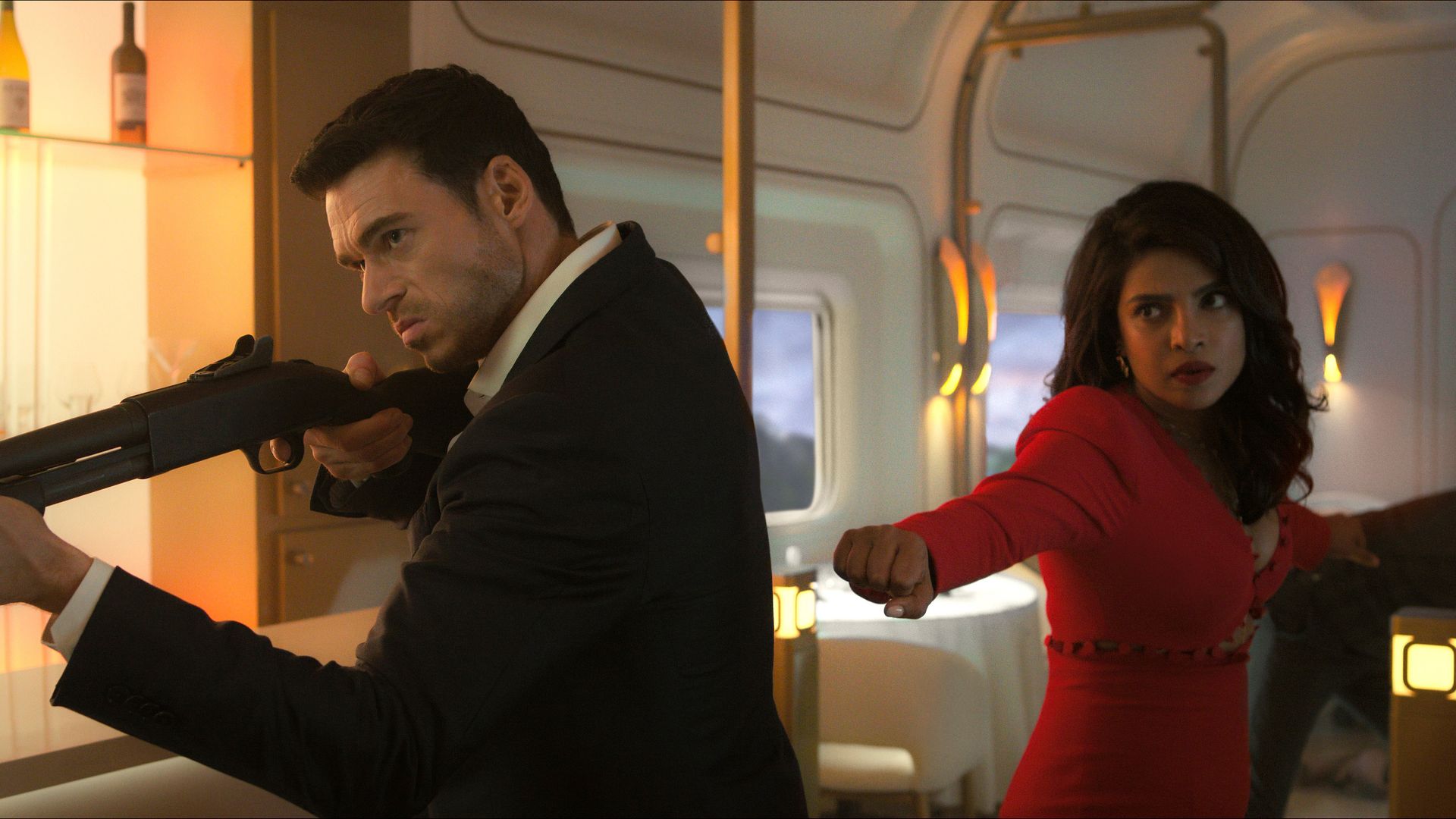 Mason holds a gun while Nadia prepares to fight in the train scene during episode one of Citadel