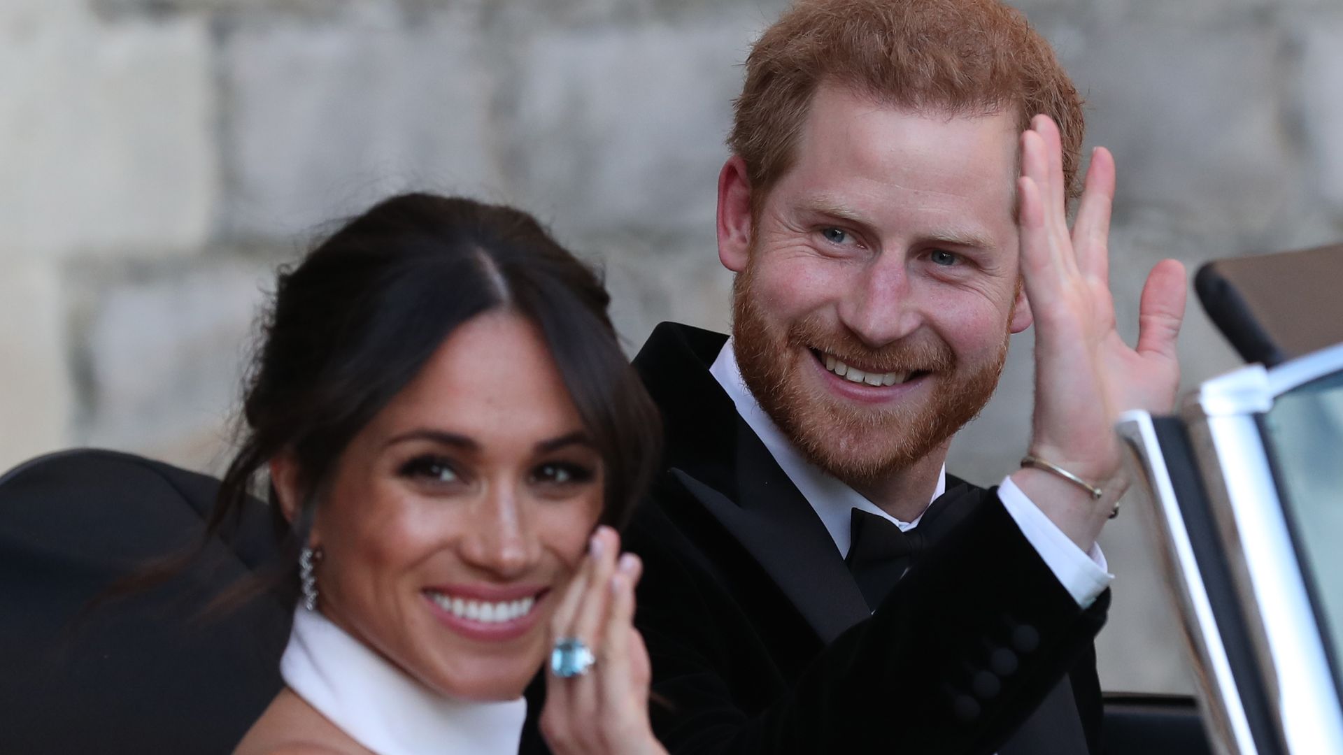 Meghan Markle and Prince Harry waving to crowds as they headed to their wedding reception