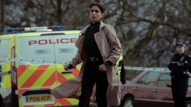 Woman running in street in front of police van