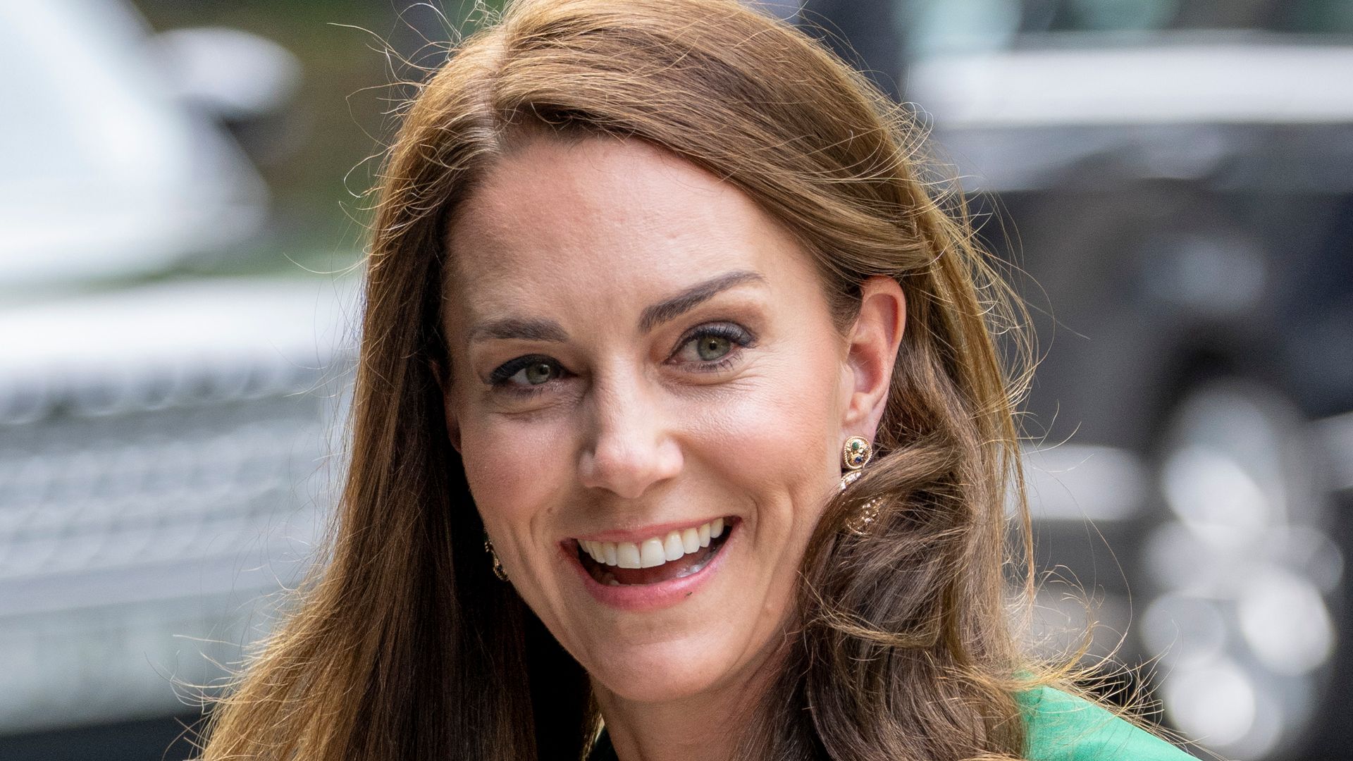 Kate Middletom with curly brunette hair green dress and Accessorize earrings