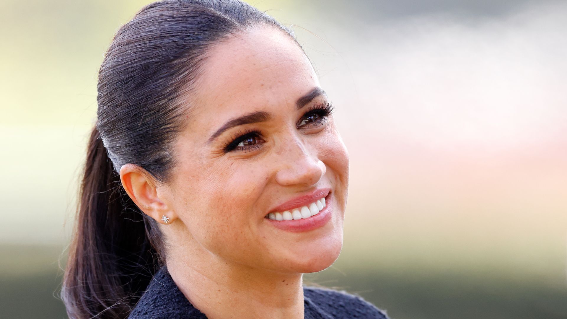 Meghan Markle with hair in ponytail smiling