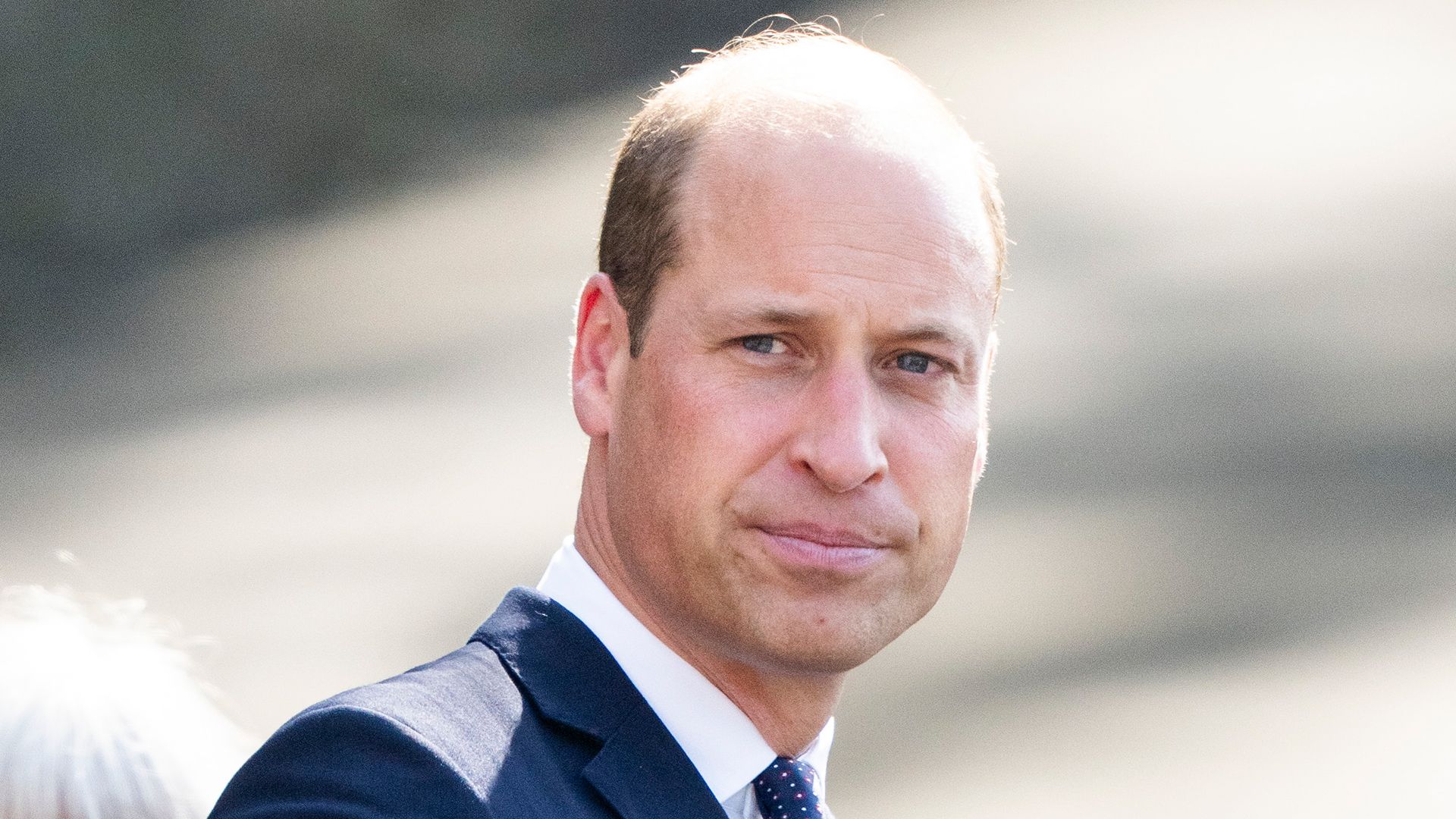 Prince William wearing a navy suit and white shirt 