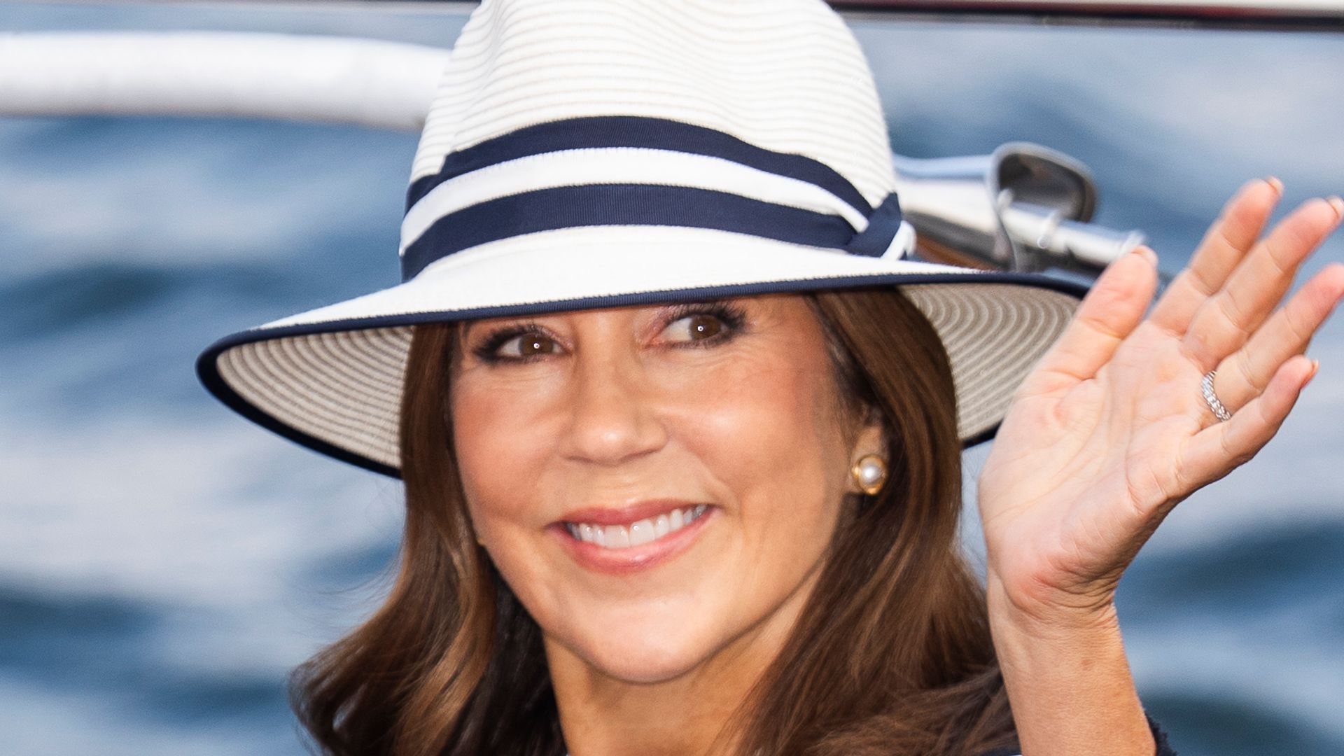 Queen Mary waving on ship in white dress