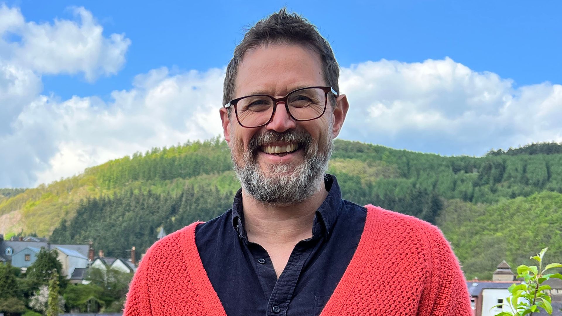 Alistair Appleton in a red jumper and denim outfit