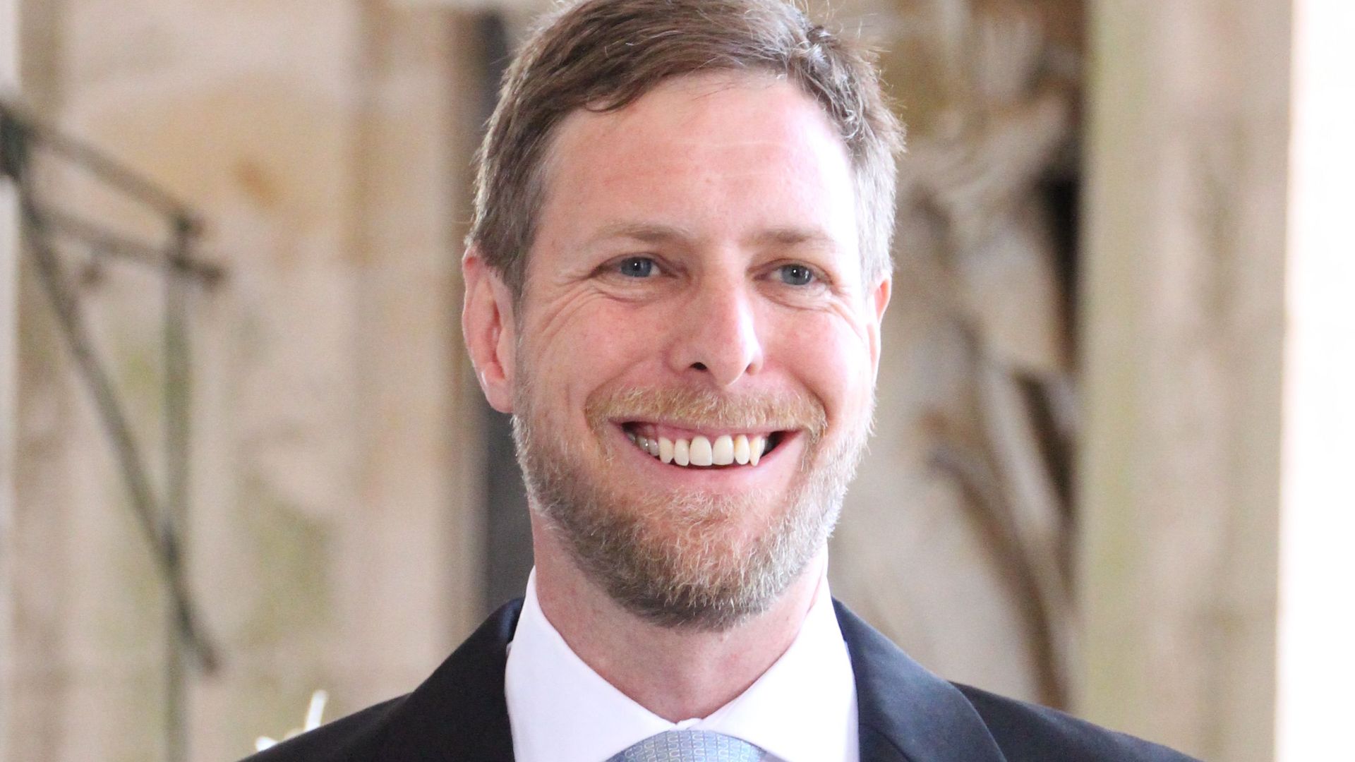Crown Prince Leka in a suit and blue tie smiling