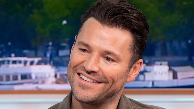 Mark Wright in brown jacket and black top