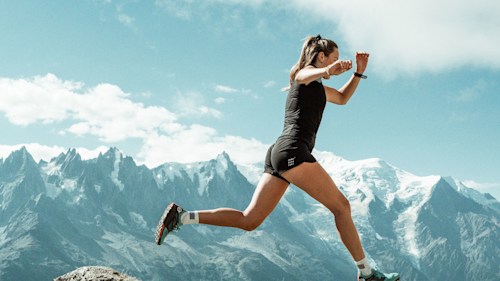 Woman leaping on rocks in the mountains 