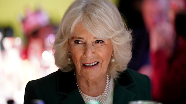 Britain's Queen Camilla reacts as she attends a "Festive Spread" Christmas lunch with volunteers, staff and celebrity supporters in London