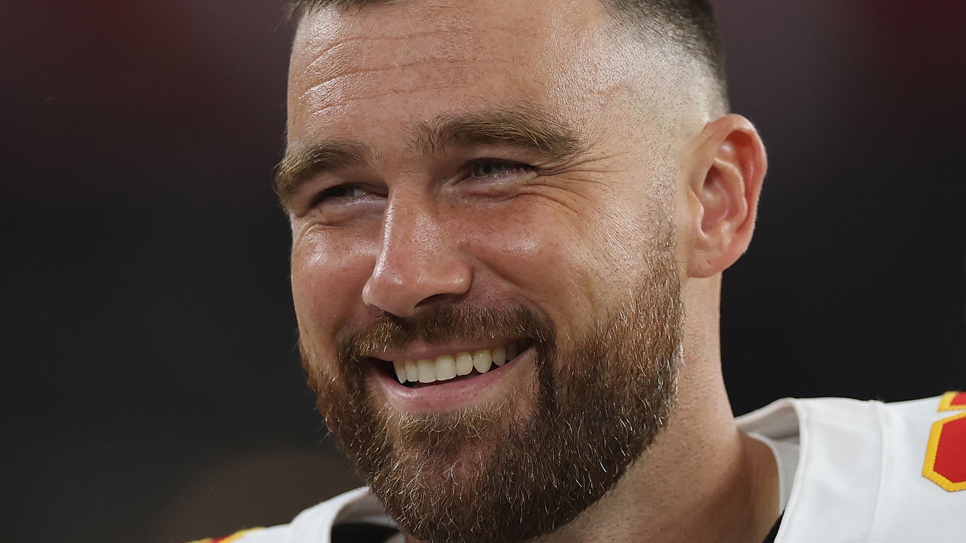 travis kelce smiling in chiefs uniform