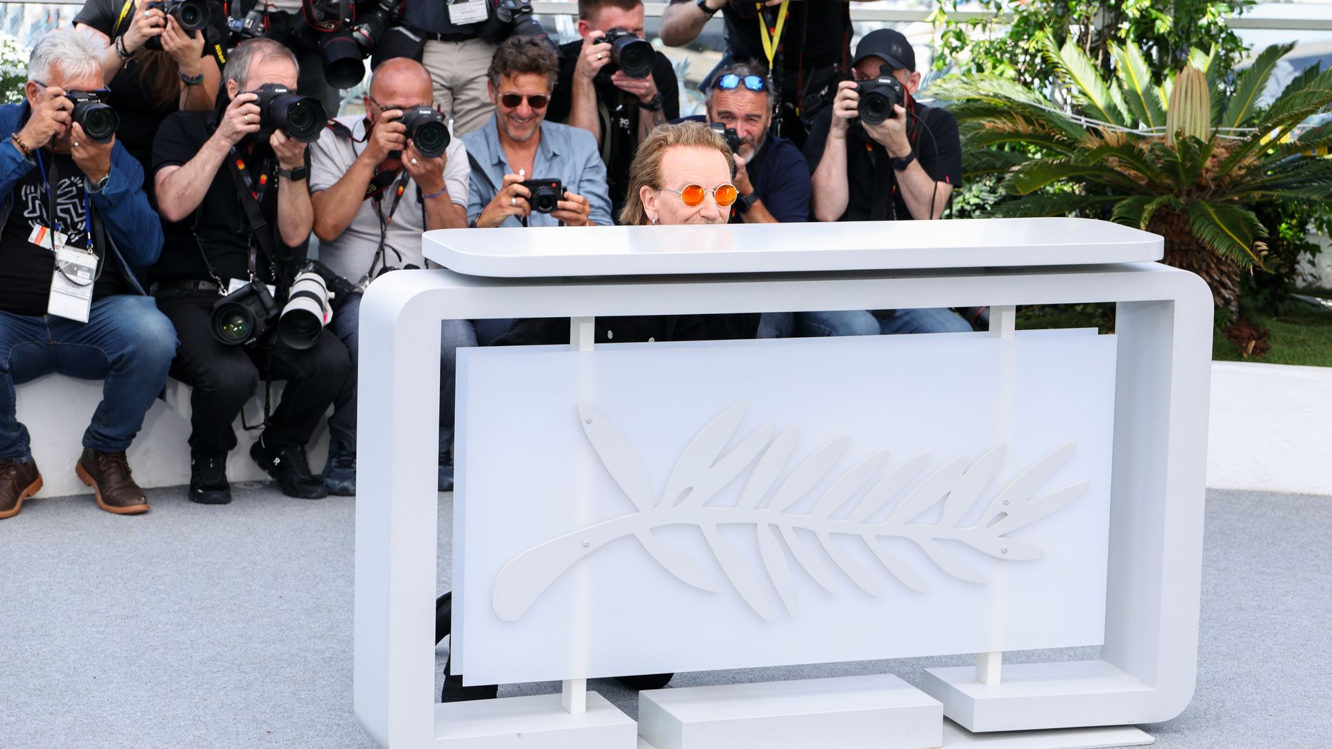 Bono hiding behind a desk