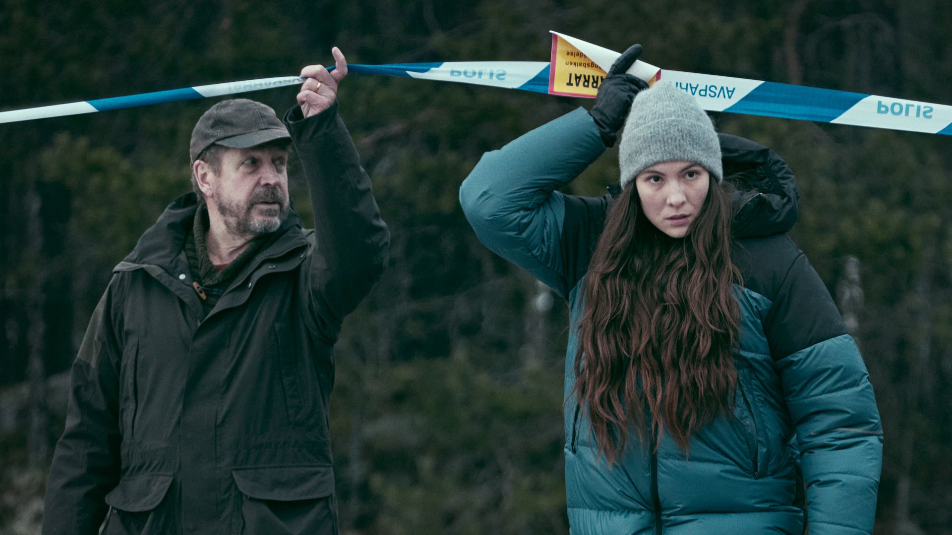 man and woman walking under police tape